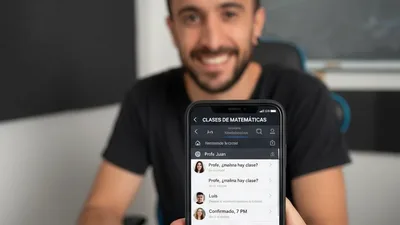 Juani mostrando en su móvil el chat del grupo de clases de matemáticas, con las consultas de sus estudiantes